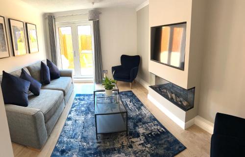a living room with a couch and a fireplace at 3 bedroom - 2 bathroom Townhouse in Corstorphine Near Murrayfield Stadium - Direct Bus To Edinburgh City Centre in 20 Minutes - Two Private Parking Spaces - Private Sunny Garden - Recently Refurbished in Edinburgh