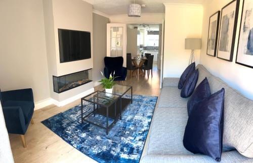 a living room with a couch and a fireplace at 3 bedroom - 2 bathroom Townhouse in Corstorphine Near Murrayfield Stadium - Direct Bus To Edinburgh City Centre in 20 Minutes - Two Private Parking Spaces - Private Sunny Garden - Recently Refurbished in Edinburgh