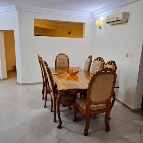a dining room with a wooden table and chairs at Sleek 2BRM at Ridge, Accra in Accra