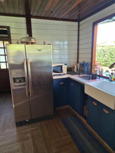 a kitchen with a stainless steel refrigerator and a sink at Casa Raízes - Atibaia in Atibaia