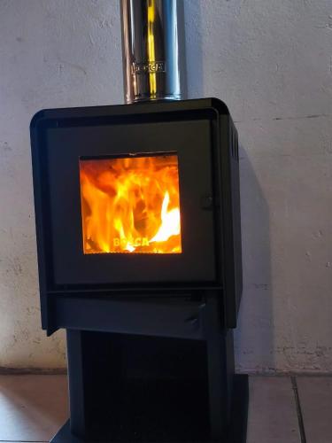 a stove with a fire inside of it at Espacio Borde Rio, Casa Pisqu in Vicuña