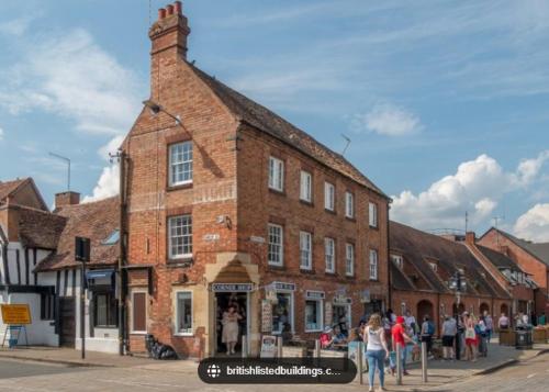 a group of people standing outside of a brick building at Shakespeare's Writing Den On Riverside in Stratford-upon-Avon