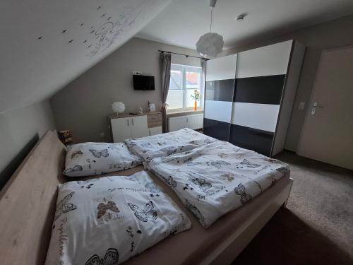 a bedroom with two beds with white sheets and a window at Ferienwohnung Mühlenhof in Duderstadt