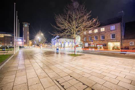 an empty city street at night with buildings at Shakespeare's Writing Den On Riverside in Stratford-upon-Avon