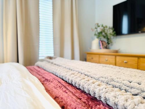 a bed with a blanket on it with a window at 3BR Oasis DT ORL, Full Kitchen & Fenced Yard! in Orlando