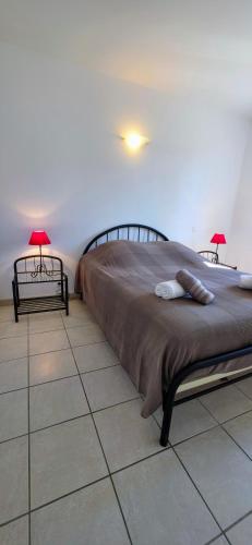 a bedroom with a large bed with two lamps on it at Gîte Nidu, un coin de paradis Provençal in Le Barroux