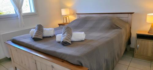 a bedroom with a bed with slippers on it at Gîte Nidu, un coin de paradis Provençal in Le Barroux