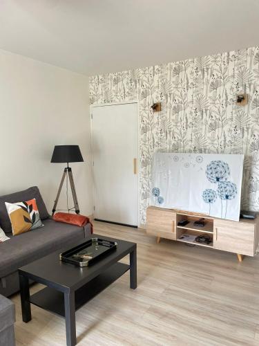 un salon avec un canapé et une table dans l'établissement Maison proche de Fougères, à Romagné