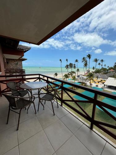 a balcony with a table and chairs and the beach at Kariri Beach Residence in Caucaia