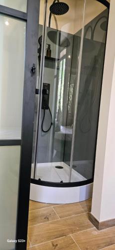 a glass shower in a room with a wooden floor at Chambres d'hôtes à 5min de Pairi Daiza et proche du SHAPE-OTAN in Lens