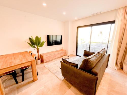 a living room with a couch and a table at El Campello Ocean View Escape in La Venteta