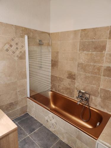 Un baño con ducha y bañera marrón. en Le nid douillet, en Saint-Étienne-de-Tinée
