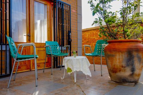 a patio with chairs and a table and a plant at Excellentia Antsirabe in Antsirabe