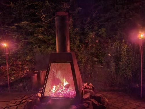 a stove with a fire in it at night at Gîte Le Trésor Caché Bed & Breakfast in Chelsea