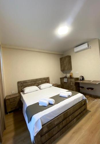 a bedroom with a large bed with towels on it at Hotel Umbrella in Shekvetili