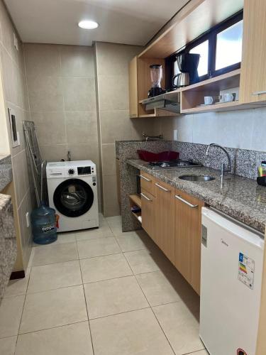 a kitchen with a washing machine and a washer at Kariri Beach Residence in Caucaia