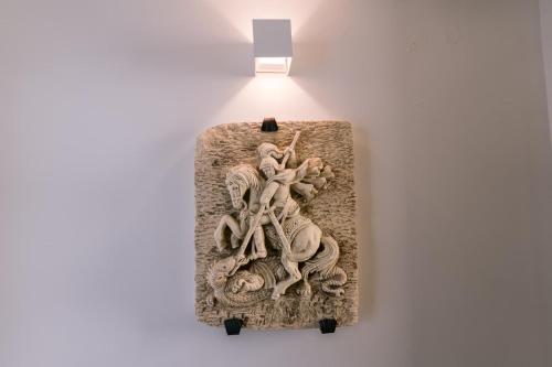 a sculpture of people on a wall with a light at Hotel Villa Paradiso in Taormina