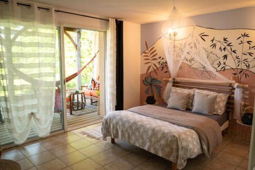 une chambre avec un lit et une grande fenêtre dans l'établissement Les gardiens de la vallée, à Figeac