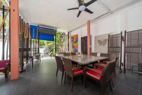 a dining room with a table and chairs and a ceiling fan at Jungceylon Villa - quiet location, pool, maid in Patong Beach