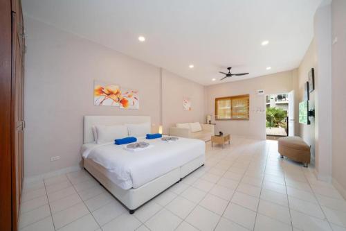 a white bedroom with a bed and a living room at Jungceylon Villa - quiet location, pool, maid in Patong Beach