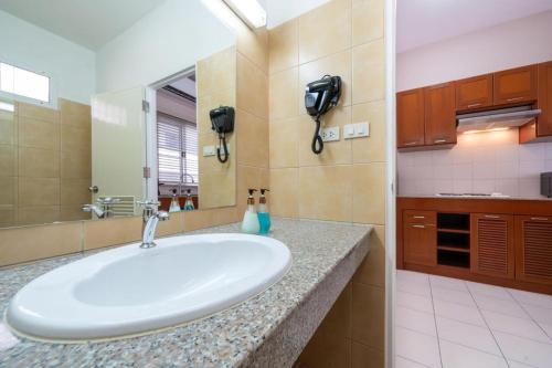a bathroom with a sink and a phone on the wall at Jungceylon Villa - quiet location, pool, maid in Patong Beach