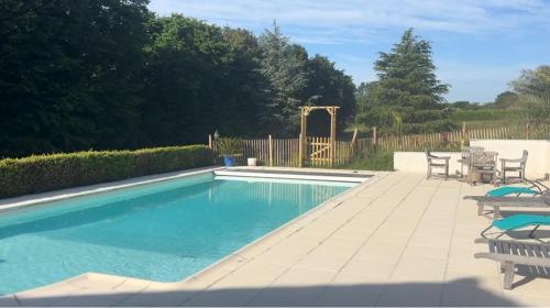 une piscine avec des chaises et une table dans l'établissement Au clos des hirondelles, à Sompt