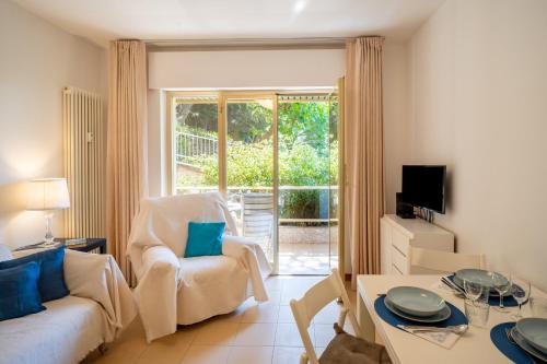 ein Wohnzimmer mit Sofa und Tisch in der Unterkunft GuestHost - Modern Escape with Pool & Sunny Terrace in Sanremo