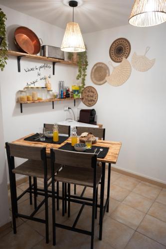 - une cuisine avec une table en bois, des chaises et des verres de jus d'orange dans l'établissement Les gardiens de la vallée, à Figeac