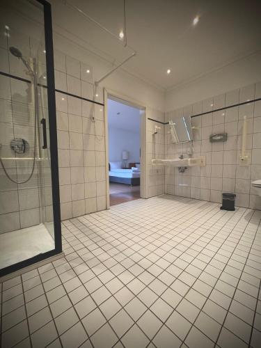 a large bathroom with a shower and a sink at Erlanger Hof in Berlin