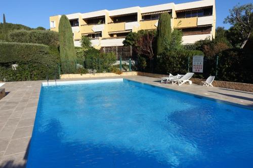 une grande piscine bleue devant un immeuble dans l'établissement Les jardins de Bandol, piscine privée, belle vue mer, à Bandol