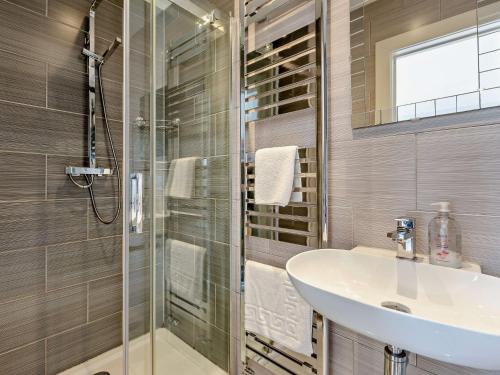a bathroom with a sink and a glass shower at 4 Bed in Braunton 78250 in Braunton