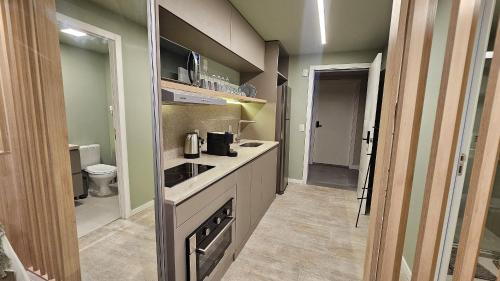 a small kitchen with a sink and a counter top at Estúdio Moderno em área nobre de Porto Alegre - Conforto e Aconchego em Cada Detalhe in Auxiliadora