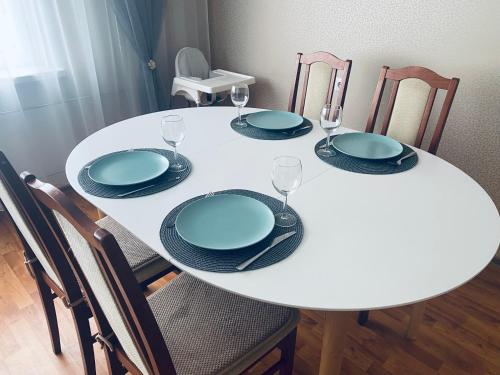 a white table with plates and glasses on it at Suuresilla in Kuressaare