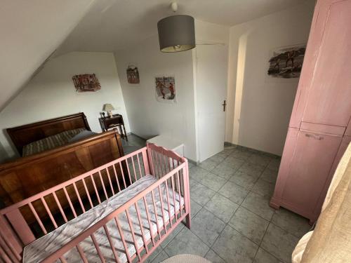 a small room with a crib and a couch at Gite de Lavardin in Saint-Aubin-de-Locquenay
