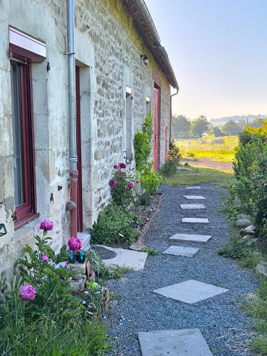 a stone building with a pathway next to a house at La Bruyère - B & B - in Tréban