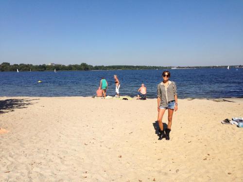 a man standing on a beach near the water at Hotel-Pension Hafemann in Senftenberg