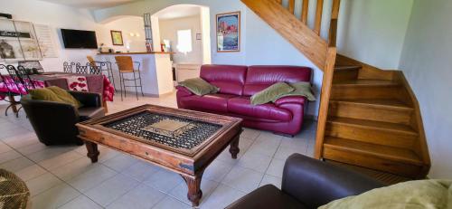 ein Wohnzimmer mit einem lila Sofa und einem Tisch in der Unterkunft Gîte Palma, vue exceptionnelle vallée Provençale in Le Barroux