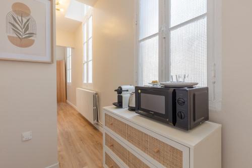 - un four micro-ondes installé au-dessus d'un comptoir dans l'établissement Le Nid des Chartrons - Suite privée élégante au cœur de Bordeaux, à Bordeaux