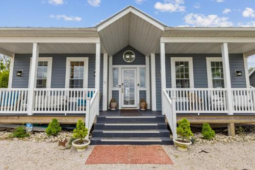 a gray house with a white front porch and stairs at Lakefront Beach House - Sauna & Steam Pod Retreat in Ashtabula