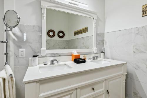 a white bathroom with a sink and a mirror at Lakefront Beach House - Sauna & Steam Pod Retreat in Ashtabula