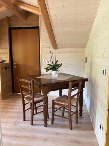 a wooden table with chairs and a vase of flowers on it at Le Moline b&b in Masserano