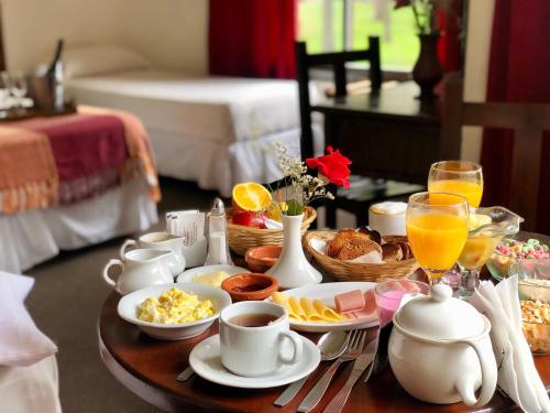 a breakfast table with breakfast foods and drinks on it at Villa de Merlo All Inclusive & Spa by MH in Merlo