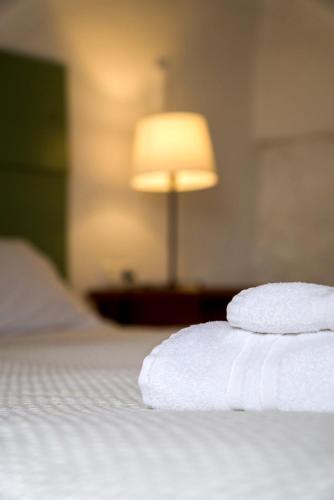 a stack of towels on a bed with a lamp at Agroturismo Binissafullet Vell in Sant Lluis