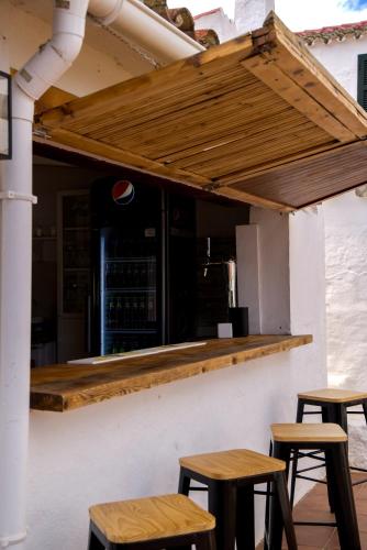 a bar with wooden stools in front of a building at Agroturismo Binissafullet Vell in Sant Lluis