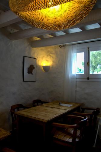 a dining room table with chairs and a light at Agroturismo Binissafullet Vell in Sant Lluis