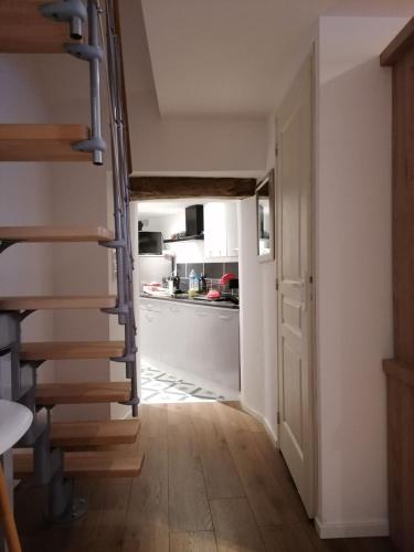 un couloir avec un escalier en colimaçon dans une cuisine dans l'établissement Charmante maison de vacances 45 minutes des plages, à Bains-sur-Oust