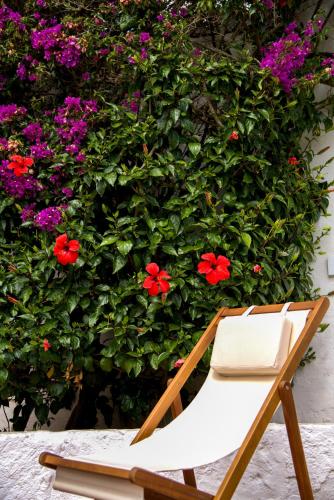 a chair in front of a wall with flowers at Agroturismo Binissafullet Vell in Sant Lluis