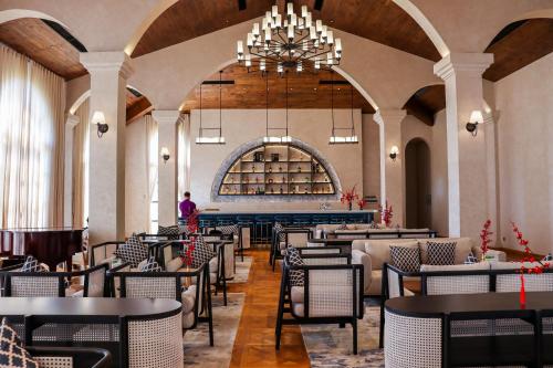 a restaurant with tables and chairs and a chandelier at Centara Mirage Resort Mui Ne in Mui Ne