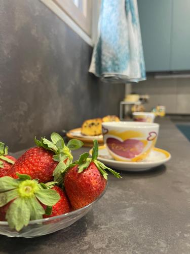 Een schaal aardbeien op het aanrecht met een kop koffie erbij. bij Il Cortile in Nocera Inferiore