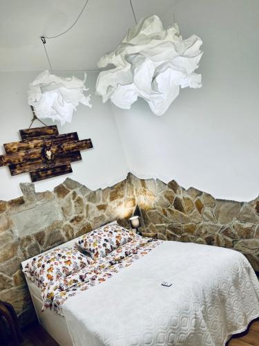 a bedroom with a bed with a stone wall at Agro Bieszczady Sleep Tourism in Czarna